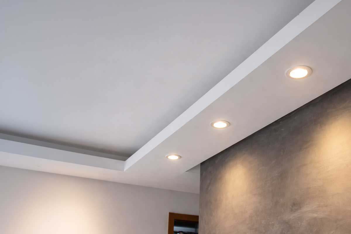 Bodová světla ve stropě osvětlující strukturovanou stěnu technikou wall washing